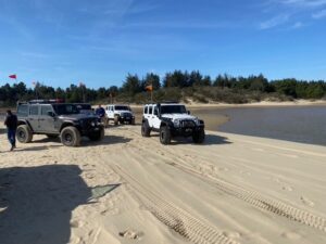 Jeeps parked near a lake in the Oregon dunes